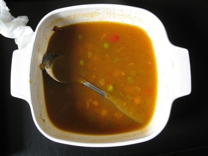 Plato de comida con una cuchara sumergida dentro ella 