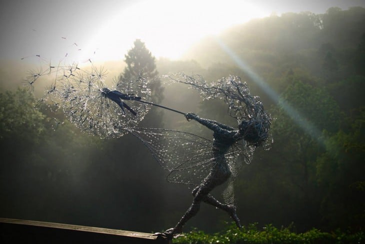 Escultura de hada hecha con alambre sosteniendo un diente de león 