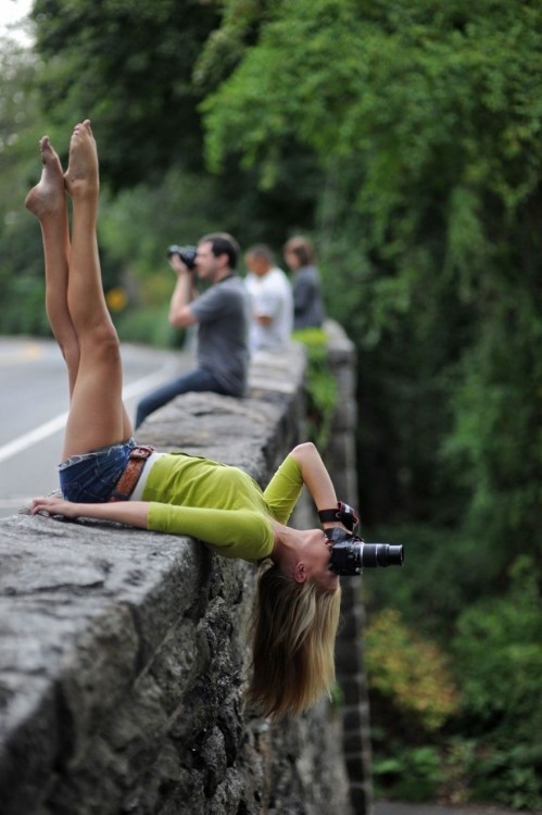 Fotógrafa acostada y de cabeza en una piedra 