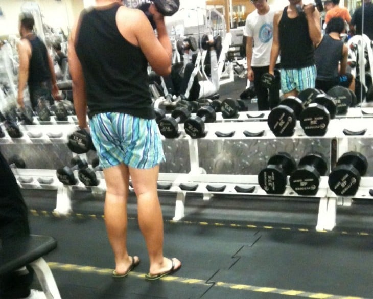 Chico en un gimnasio vestido con sandalias y short 