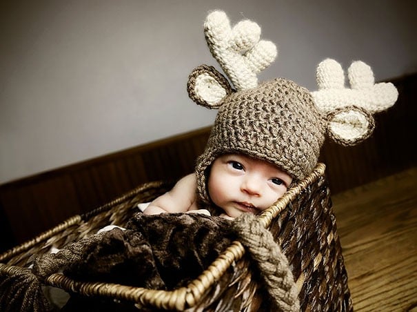 Bebé con un gorro de estambre con la forma de siervo