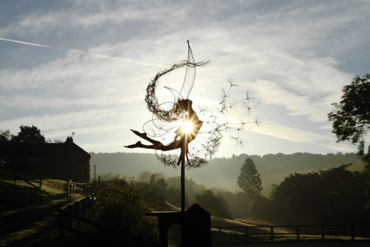 Escultura de hada a contra luz que parece estar viendo hacia arriba 