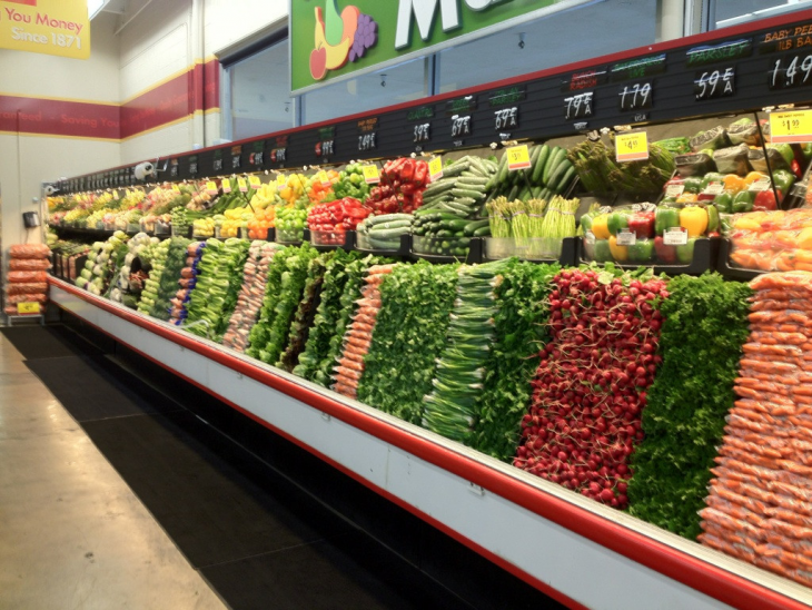 Pasillo de verduras en un supermercado ordenado por colores y verduras 