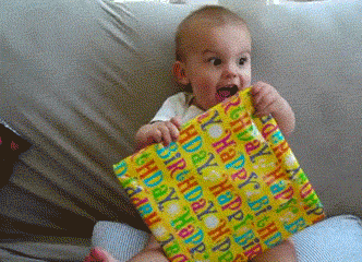 GIF de Un bebé emocionado con un regalo en sus manos 