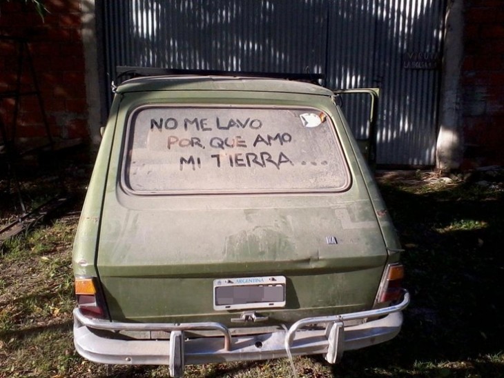 Carro con un mensaje en su parabrisas trasero lleno de tierra 