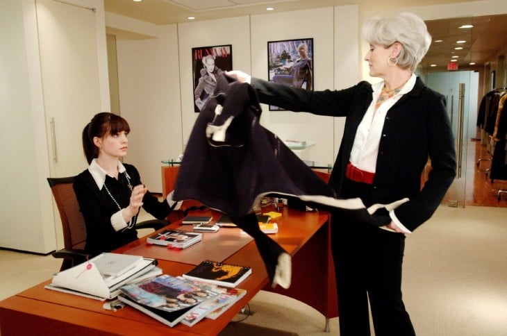 Escena de la película el diablo viste a la moda donde Miranda le da un saco a Andrea sentada en el escritorio 