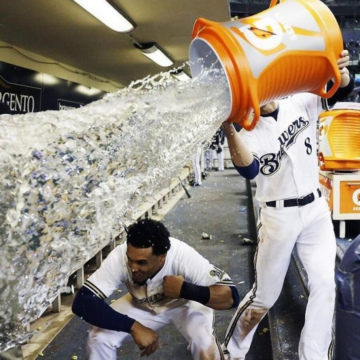 Béisbolista vaciando un garrafón de agua sobre un compañero 