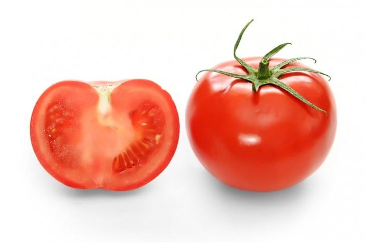 Fotografía con la mitad de un tomate junto a un tomate entero 