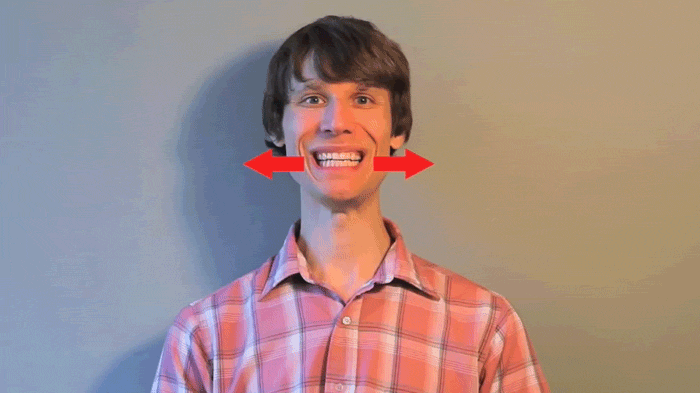 GIF de un chico sonriendo con unas flechas en color rojo a sus costados 