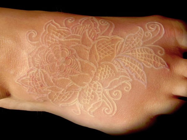 Tatuaje con tinta blanca sobre el pie de una persona 