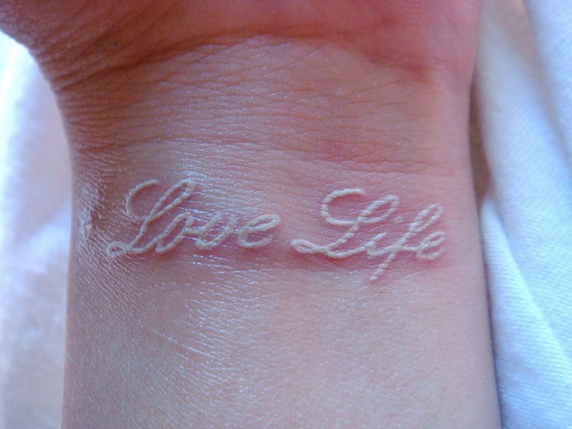 Tatuaje con letras Love Life en tinta blanca 