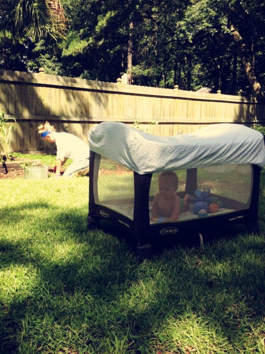 Corralito de bebé con una sábana encima en un jardín 