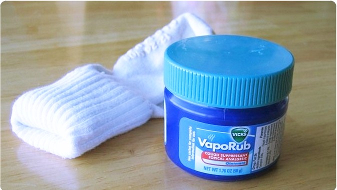 Frasco de VapoRub con unos calcetines a un costado 