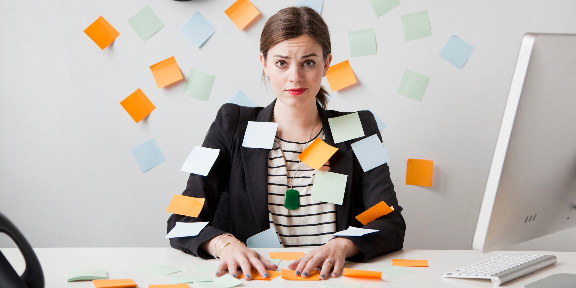 Studio shot of young woman working in office covered with adhesive notes