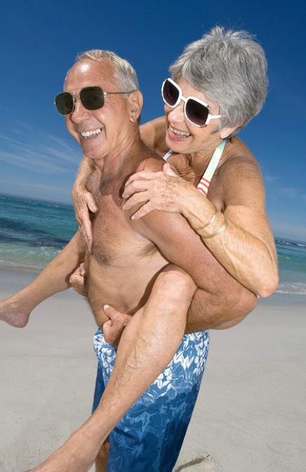 pareja de abuelos  haciendo caballito en la playa