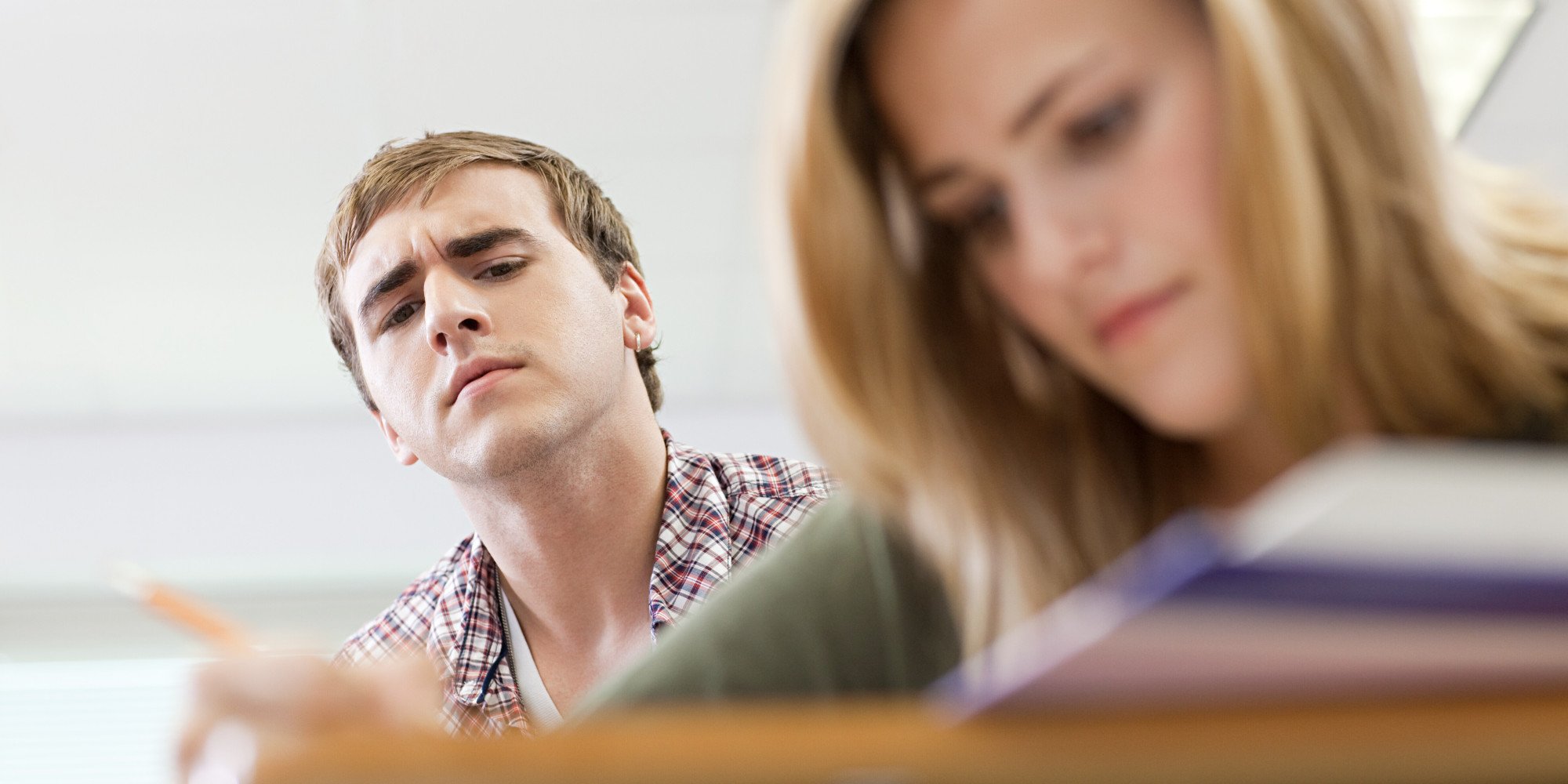 Male high school student copying classmate's work