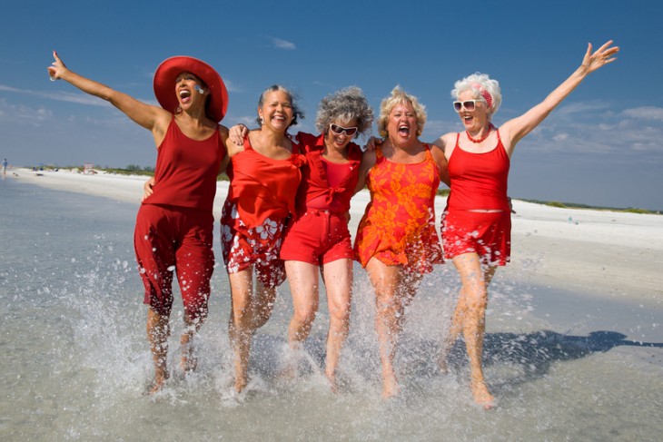 mujeres adultas mayores en la playa vestidas de rojo