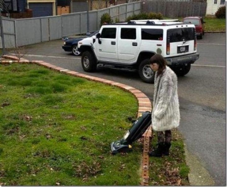 Señora pasando aspiradora en el jardín