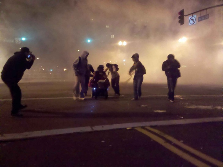 manifestantes sacan del gas lacrimogeno a mujer en silla de ruedas en oakland 2011