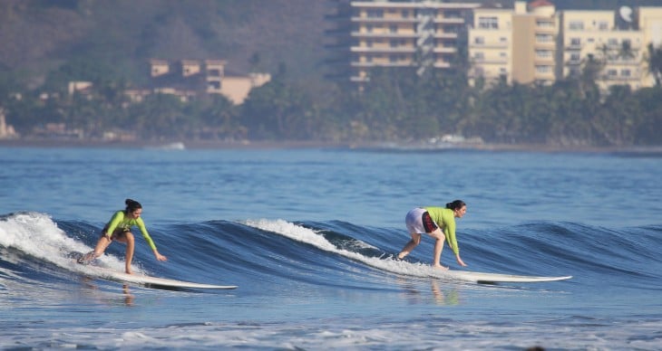 Chicas surfeando sobre la Playa Jaco en Costa Rica 