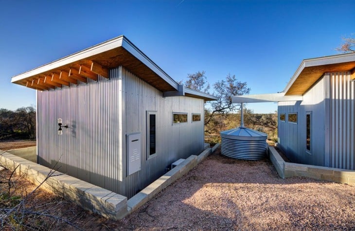 contenedor de agua entre dos cabañas construida a la orilla de un río en Texas 