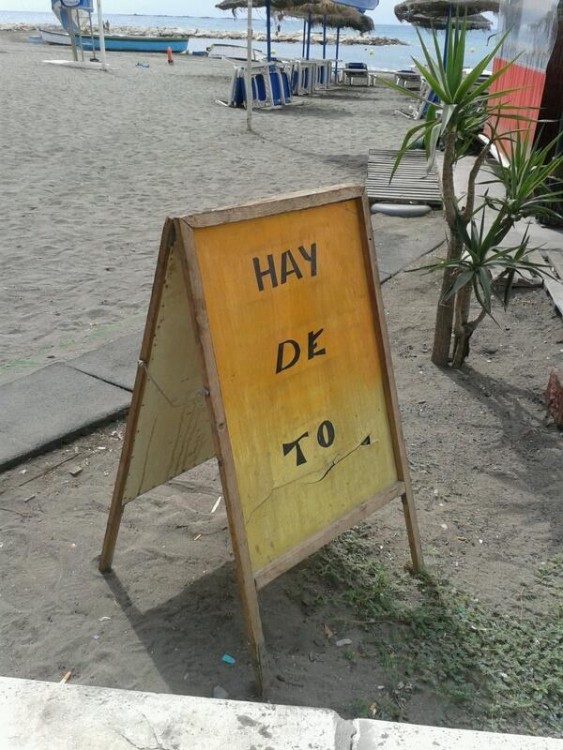 Anuncio afuera de un negocio en medio de una playa 