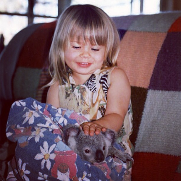 Bindi Irwin de niña acariciando a un pequeño koala 