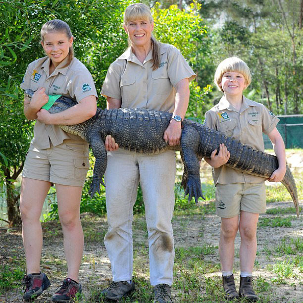 Bindi Irwin junto a su hermano y su mamá sosteniendo a un cocodrilo 