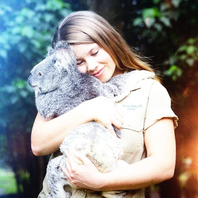 Bindi Irwin cargando y abrazando a un koala 