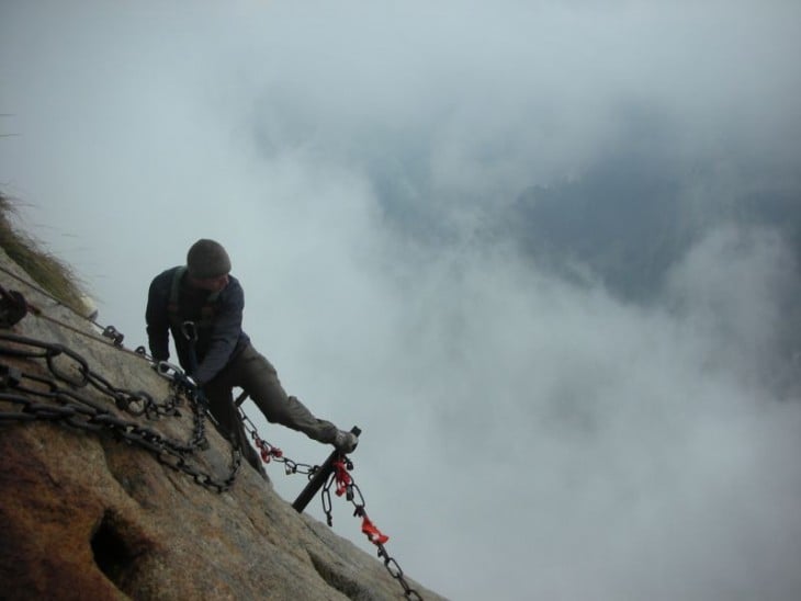 Hombre subiendo por una montaña hacia un monte en China