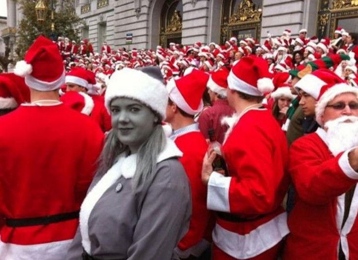 Personas vestidas de santa claus donde una chica se ve a blanco y negro 