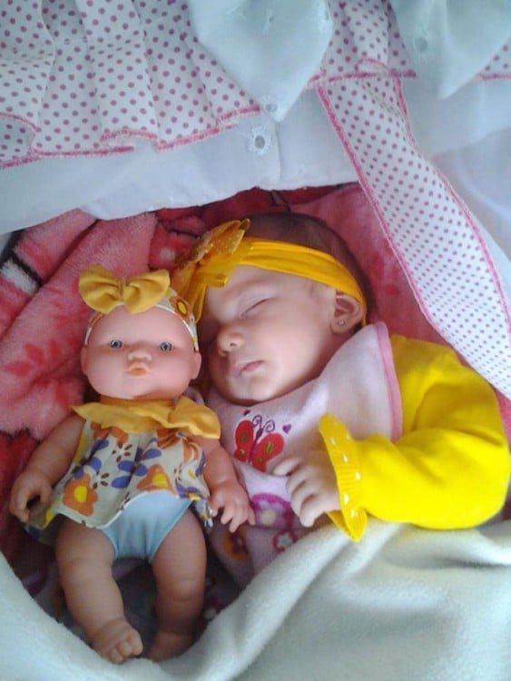 Bebé dormida junto a su muñeca vestida iguales 