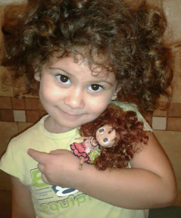 una pequeña niña abrazando a su muñeca 