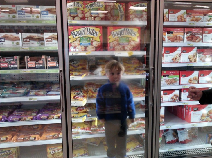 Niño dentro un congelador en el super mercado 