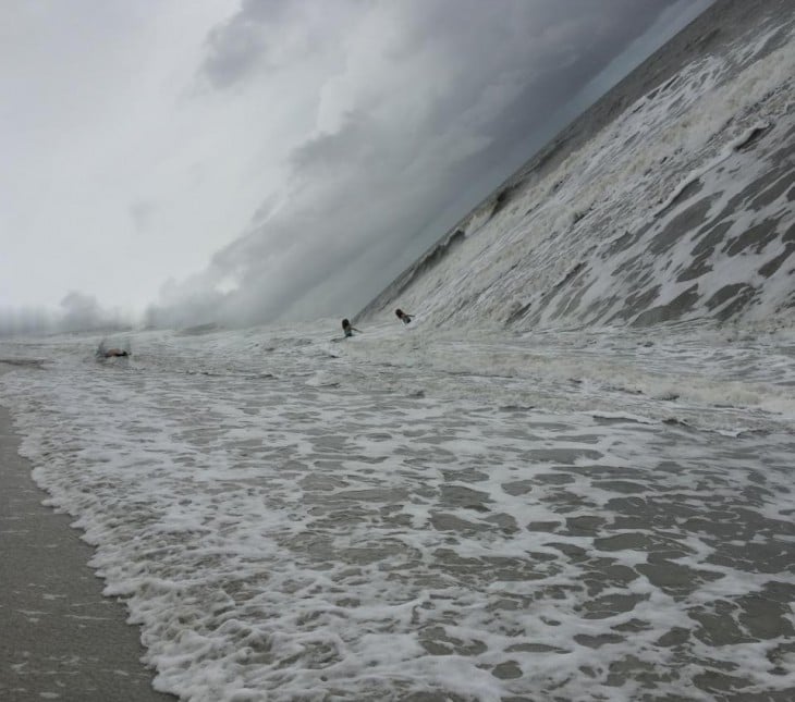 Fotografía panorámica que salio mal donde simula que el mar cae encima de dos personas 