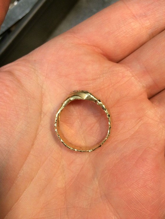 Mano sosteniendo un anillo que recobro su forma redonda después de estar triturado 