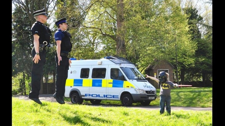 niño jugando a la guerra de las galaxias con los policias