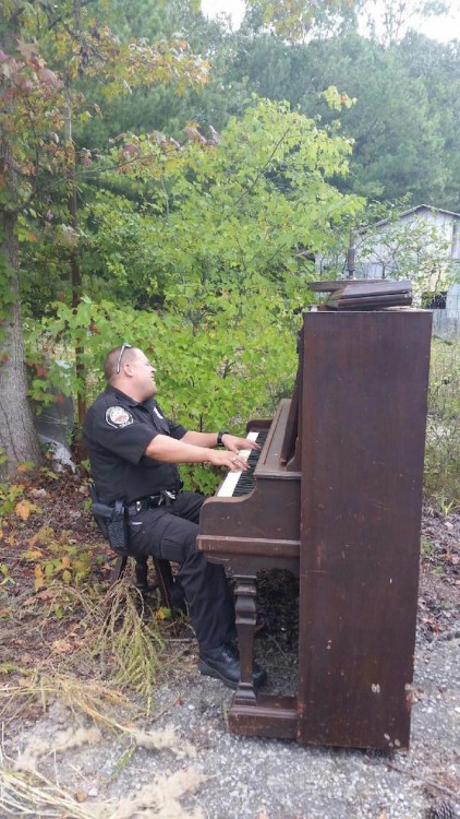 ´policia hace que toca el piano en un jardin abandonado