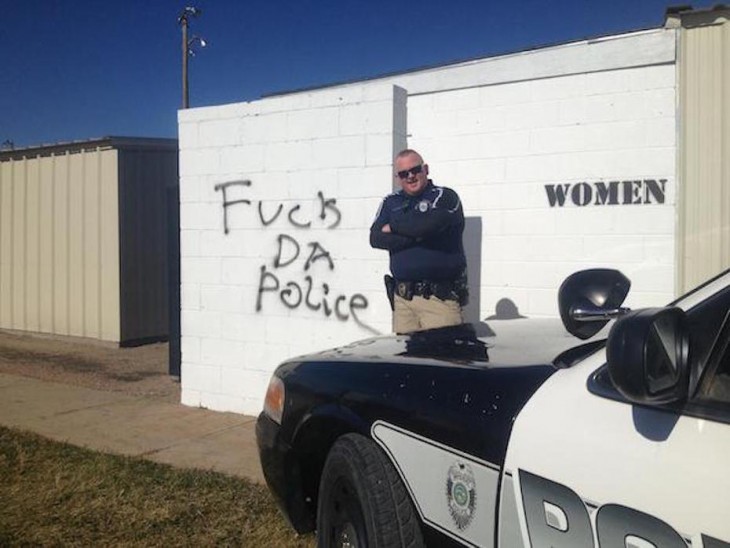 policia se burla del letrero que dice FUCK THE POLICE