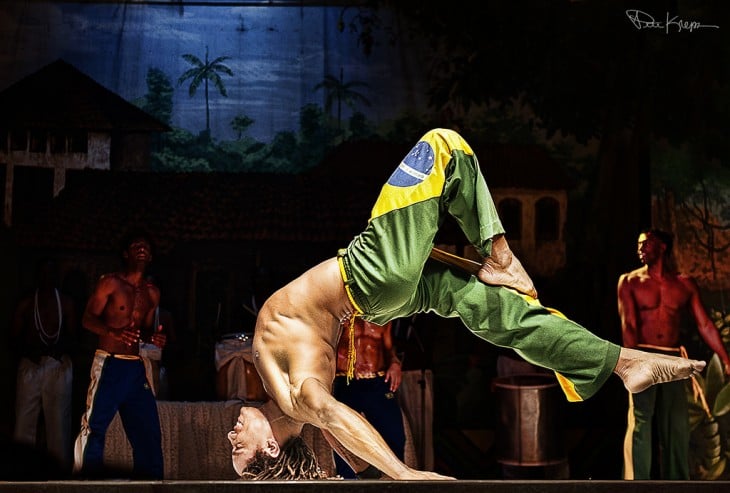 Hombre en el escenario de un teatro bailando capoeira