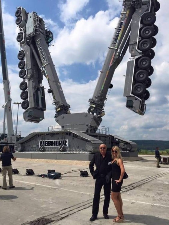 fotografía de dos personas frente a una maquina que parece un transformer 