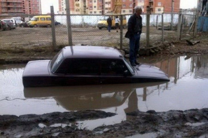 un carro hundido en agua en medio de la calle 