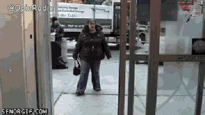 GIF de una mujer que se asusta con una puerta automática