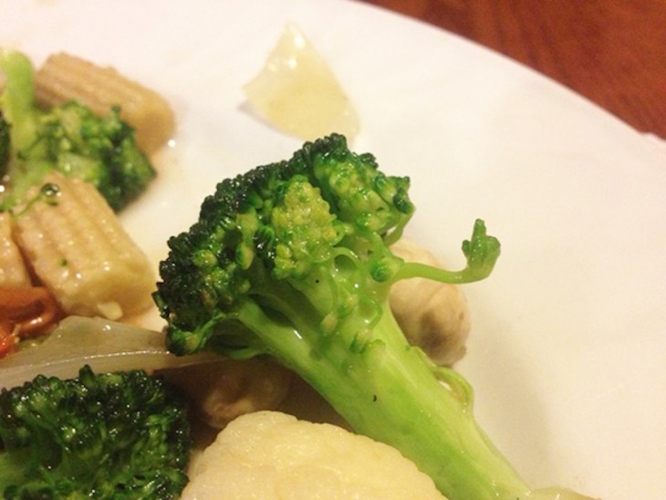 Brocoli que simula tener una mano hacia arriba en un plato con verduras 