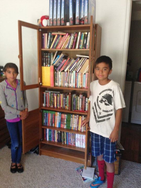 Mateo y su hermana Jazmín junto a un librero 