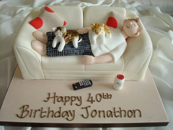 pastel de cumpleaños para un chico acostado en un sillón con dos gatos 