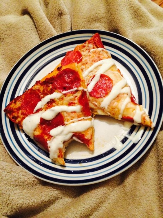 Trozos de pizza sobre un plato con aderezo ranch 