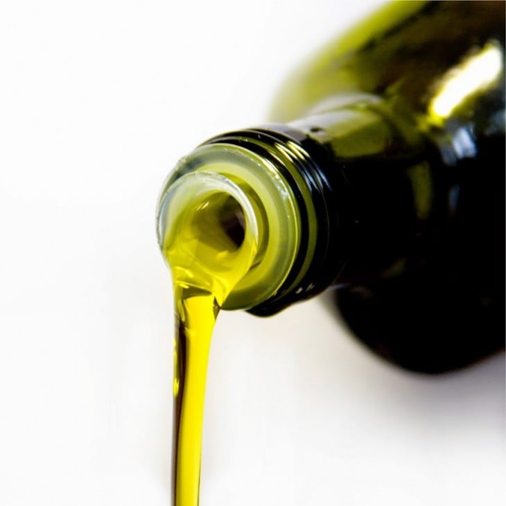 Botella verde vertiendo aceite de oliva 