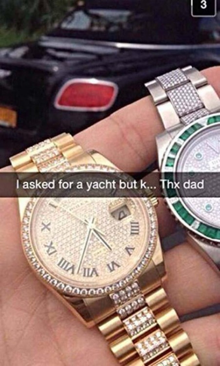 Mano de un chico sosteniendo dos costosos relojes