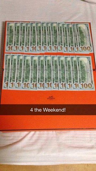 Caja de color naranja con algunos billetes sobre ella 